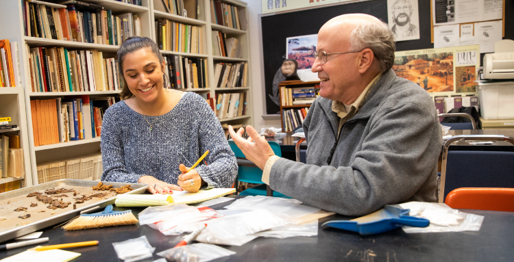 student with professor in a library